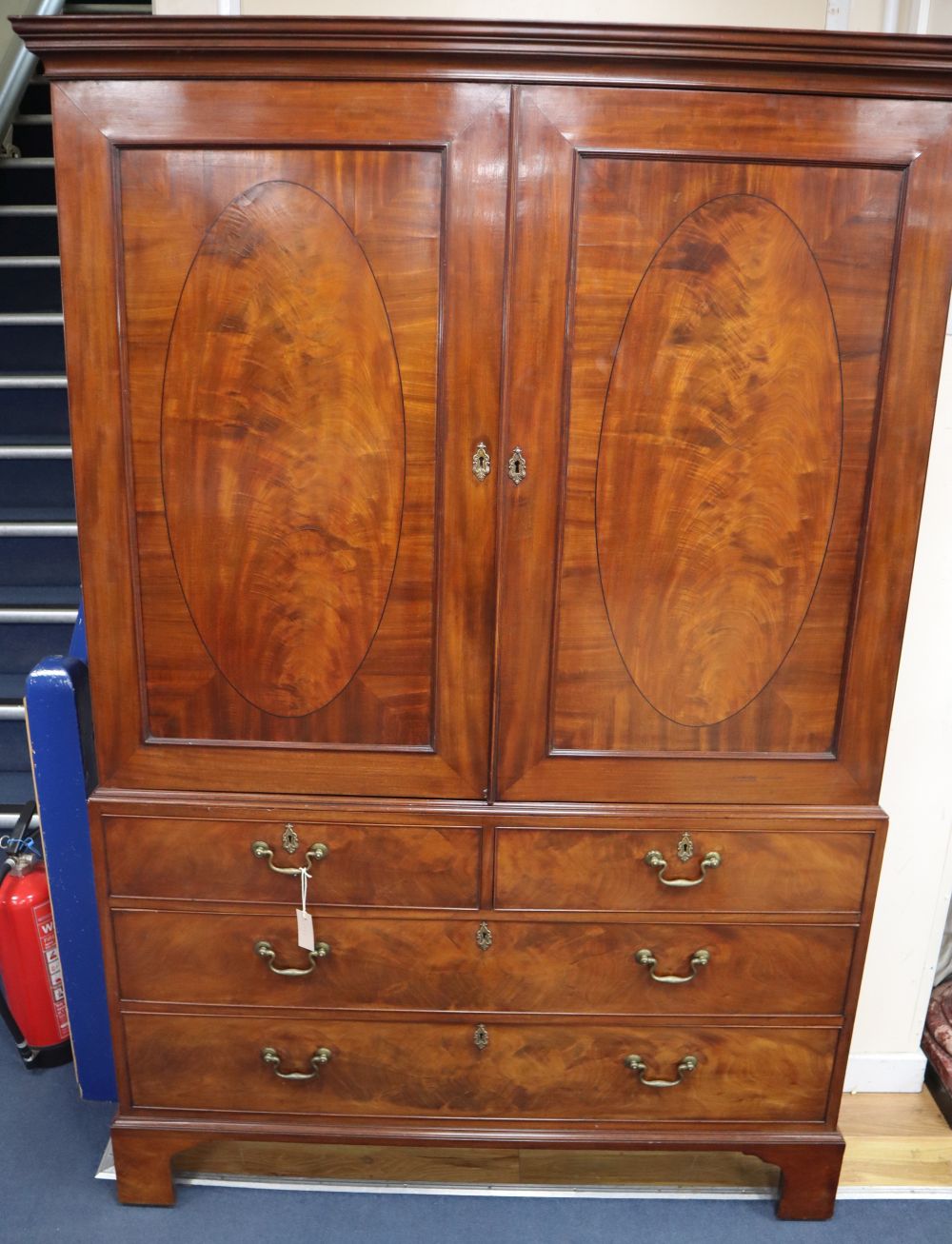 A George III mahogany linen press, oval panels, W.134cm, D.59cm, H.200cm